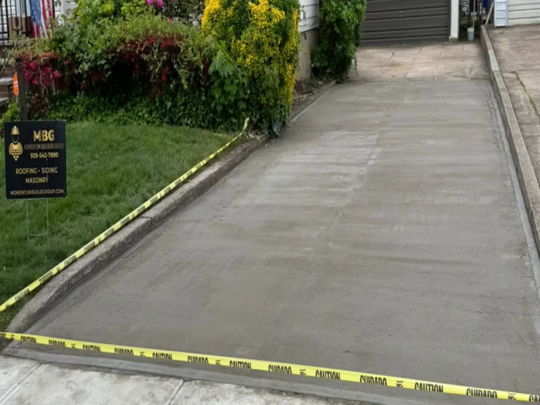 Freshly poured concrete driveway with a broom finish leading to a garage